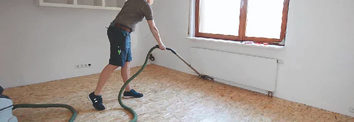 Eine Person säubert den Boden mit einem Staubsauger